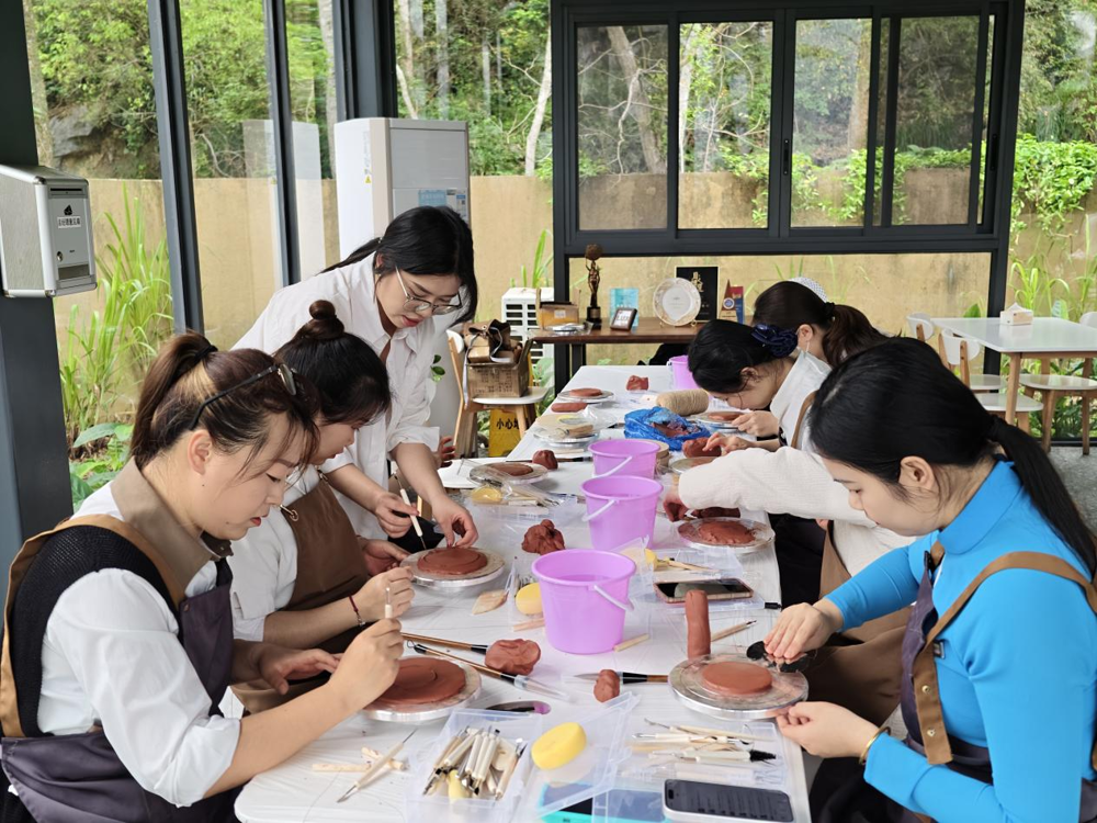 图2 钱喜倩老师指导学员用泥条盘筑陶器